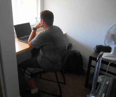 Picture for his motherof John studying in his new apartment.